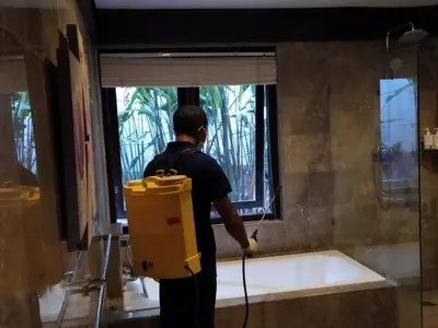a man is washing a window in a bathroom at Alysha Villa Seminyak Beachside By Bali Asia Villa in Seminyak