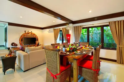 a living room with a dining table and a couch at Alysha Villa Seminyak Beachside By Bali Asia Villa in Seminyak