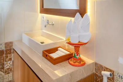 a bathroom with a sink and a wooden box at Kubu GWK Villa in Jimbaran