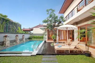 a backyard with a swimming pool and a house at Kubu GWK Villa in Jimbaran