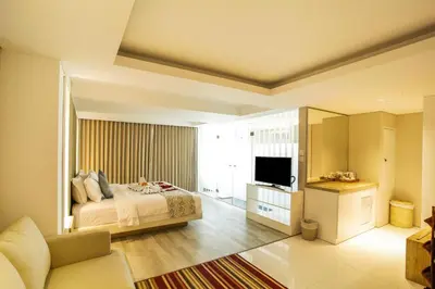 a bedroom with a bed and a television in it at Benoa Sea Suites and Villas in Nusa Dua