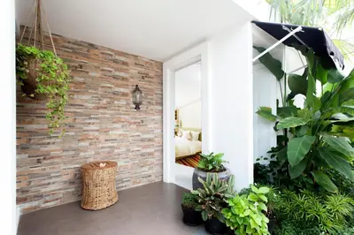 a room with a brick wall and plants at Benoa Sea Suites and Villas in Nusa Dua