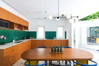 a kitchen with a wooden table and blue chairs at Villa Ungava in Seminyak