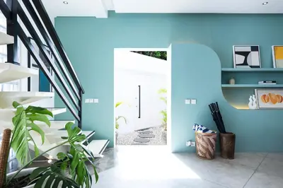 a hallway with blue walls and a white door at Villa Ungava in Seminyak