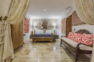 a bedroom with a bed and a couch at Villa Kundalini in Seminyak