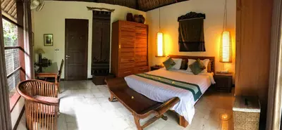 a bedroom with a bed and a chair in it at Bali Villa Aja in Seminyak