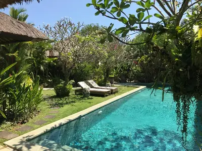 a swimming pool in a yard with a resort at Bali Villa Aja in Seminyak