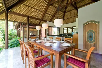 a dining room with a large wooden table and chairs at Bali Villa Aja in Seminyak