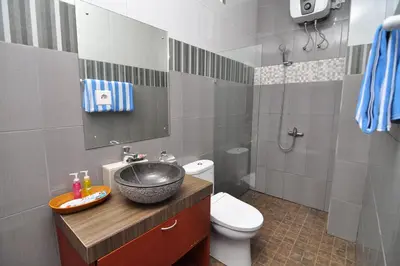 a bathroom with a sink and a toilet at Kandava Villa in Jimbaran