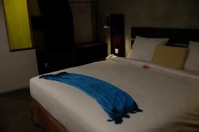 a large white bed with a blue blanket on it at Semimpi in Canggu
