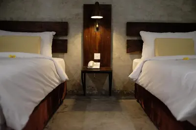 a bedroom with two beds and a table with a phone at Semimpi in Canggu