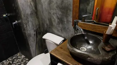 a bathroom with a black sink and a toilet at Semimpi in Canggu