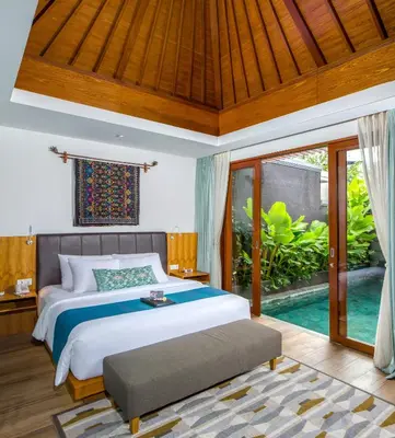 a bedroom with a large bed and a pool at S18 Bali Villas in Legian