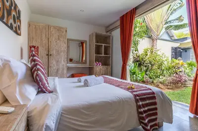 a bedroom with a bed and a large window at VILLA Nuri Merah 1 in Kerobokan