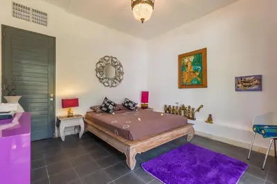 a bedroom with a bed and a purple rug at Villa Purple in Legian