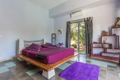 a bedroom with a large bed with purple sheets at Villa Purple in Legian