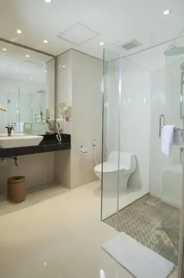 a bathroom with a shower and a toilet and a sink at Sulis Beach Hotel & Spa in Kuta