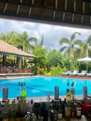 a bunch of bottles on a counter next to a swimming pool at Bali Agung Village in Seminyak