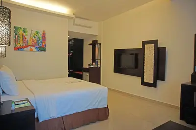 a hotel room with a bed and a tv at Best Western Resort Kuta in Kuta
