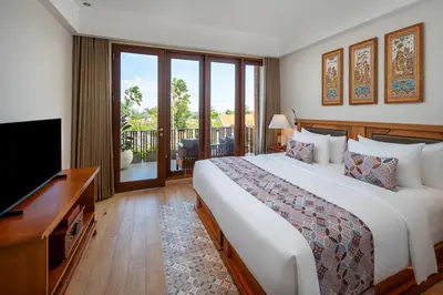 a hotel room with a large bed and a television at Kuta Seaview Beach Resort in Kuta
