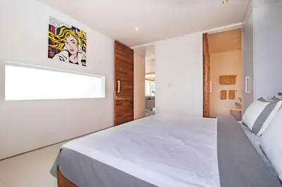 a bedroom with a large white bed and a window at Villa Kamag Seminyak in Seminyak