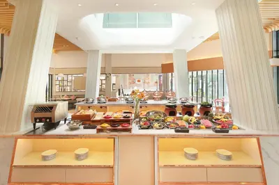 a kitchen with a buffet of food on display at HARRIS Hotel Kuta Tuban Bali in Kuta