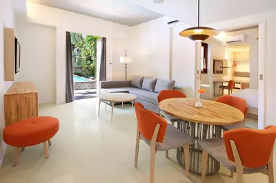 a living room with a couch and a table and chairs at HARRIS Hotel Kuta Tuban Bali in Kuta