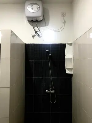 a bathroom with a shower with a light on the ceiling at The Celuk Homestay in Jimbaran