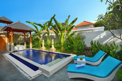 a backyard with a swimming pool and a villa at Holl Villa by Wildflower Group in Legian