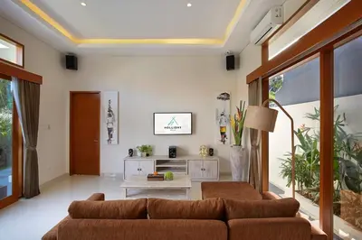 a living room with a couch and a table at Holl Villa by Wildflower Group in Legian