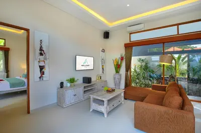 a living room with a couch and a table at Holl Villa by Wildflower Group in Legian