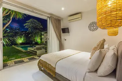 a bedroom with a bed and a large window at Villa Irma in Seminyak