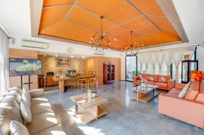 a living room with orange furniture and a large ceiling at Villa Jerami & Spa in Seminyak
