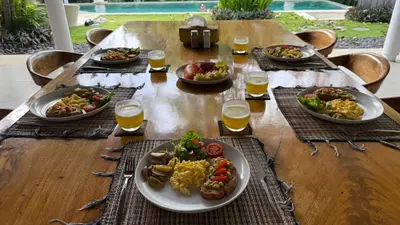 a table with plates of food and glasses of orange juice at Villa Anema Umalas in Seminyak