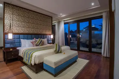 a bedroom with a large bed and a window at Natya Villa Jimbaran in Jimbaran