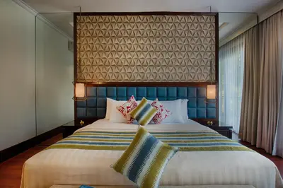 a bedroom with a large bed with a blue headboard at Natya Villa Jimbaran in Jimbaran