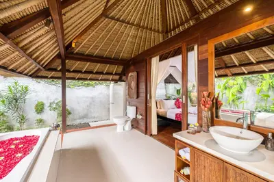 a bathroom with a tub and a sink in a room at Mayaloka Villas Seminyak in Seminyak