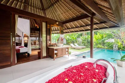 a bathroom with a tub and a swimming pool at Mayaloka Villas Seminyak in Seminyak