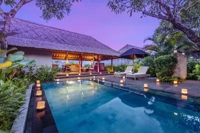 a swimming pool in front of a villa at Mayaloka Villas Seminyak in Seminyak