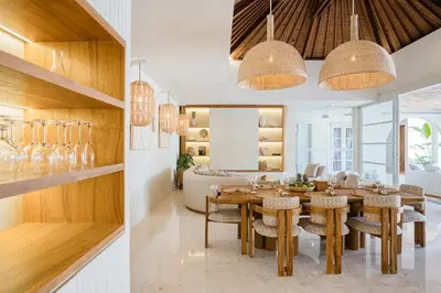 a dining room and living room with a table and chairs at Akara Villa in Seminyak