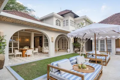 a patio with a table and chairs and an umbrella at Akara Villa in Seminyak