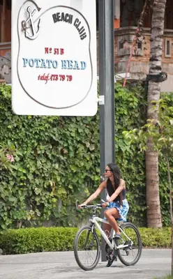 a woman riding a bike down a street with a sign at Akara Villa in Seminyak