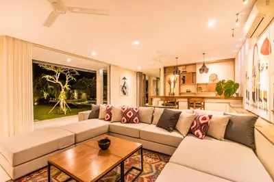 a living room with a couch and a table at Villa Seriska Jimbaran - Spacious 5BR Private Pool Villa with Private Cook, Spa & Tour in Jimbaran