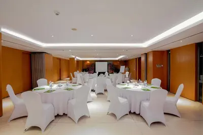 a conference room with white tables and white chairs at THE HAVEN Bali Seminyak in Seminyak
