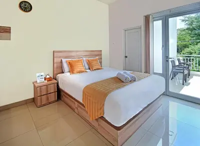 a bedroom with a bed and a balcony at Wika Bali Beach House in Jimbaran