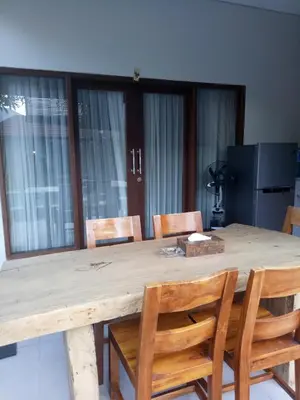 a dining room table with chairs and a wooden table at The Surya Kuta Villa in Kuta