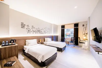 a hotel room with two beds and a television at Stark Boutique Hotel and Spa in Kuta