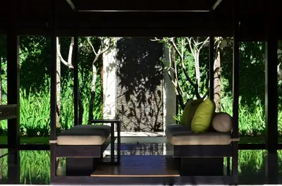 a room with two chairs and a window with trees at The Amala Boutique Retreat in Seminyak