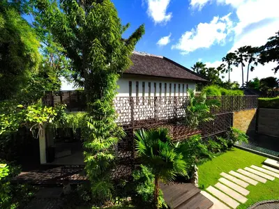 a house with a fence and a garden at The Amala Boutique Retreat in Seminyak