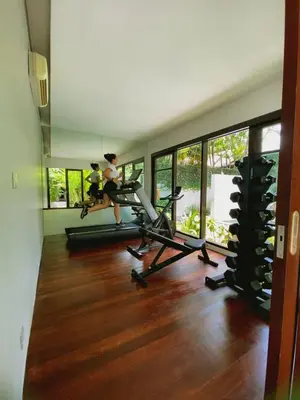 a gym with two people on treadmills in a room at The Amala Boutique Retreat in Seminyak